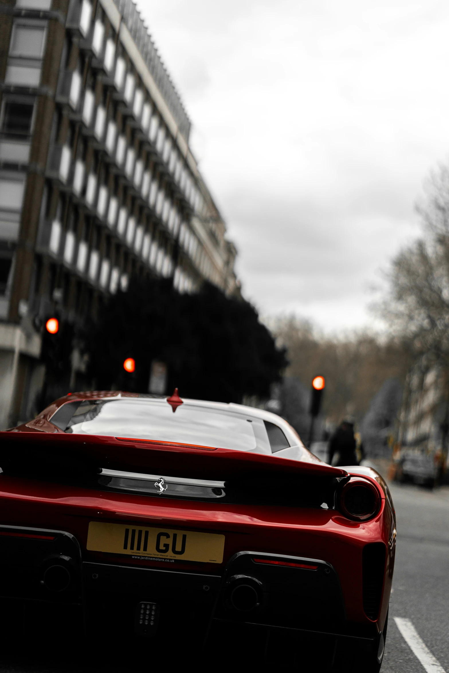 a sports car is parked along a road by a building