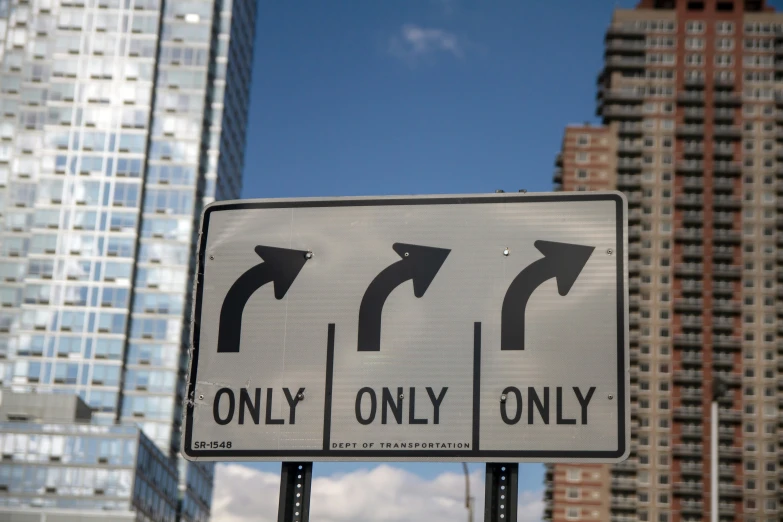 a white and black street sign showing directions to different cities