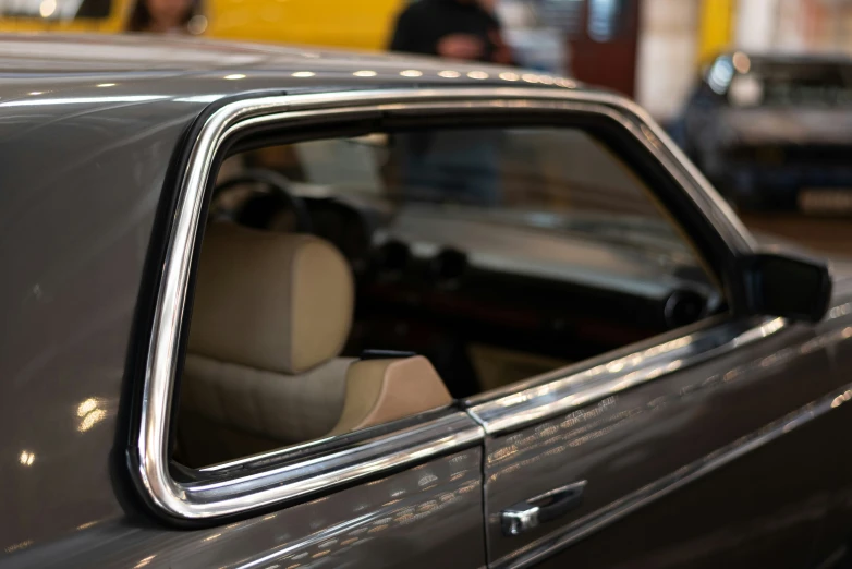 a car parked inside of a garage with people inside of the garage