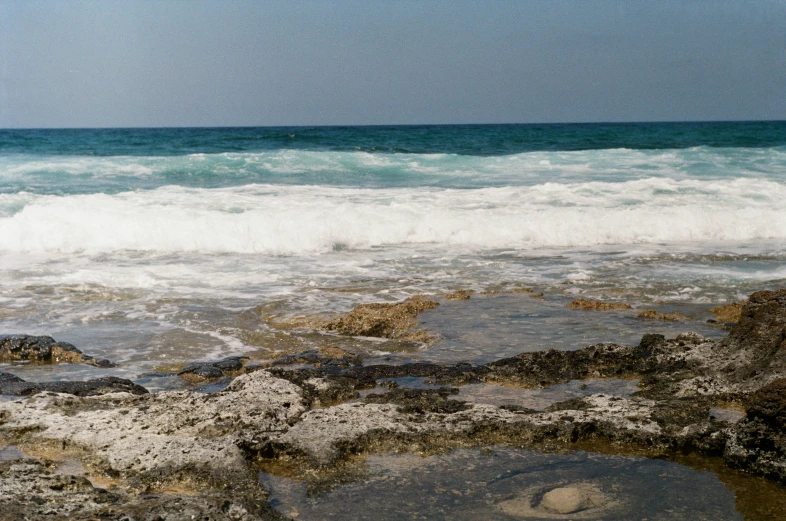 the surf is breaking the beach as the tide rolls in