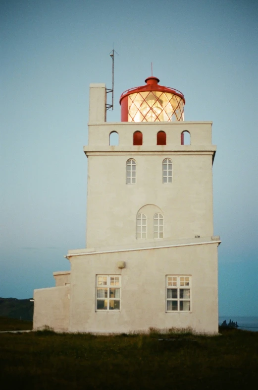 a white lighthouse is shown against a blue sky