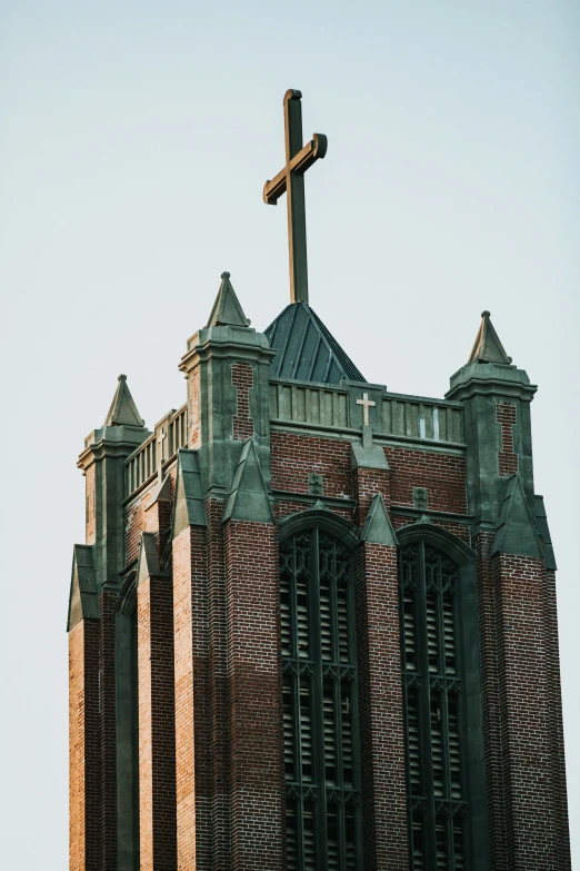 an old, red brick church with the cross on the roof