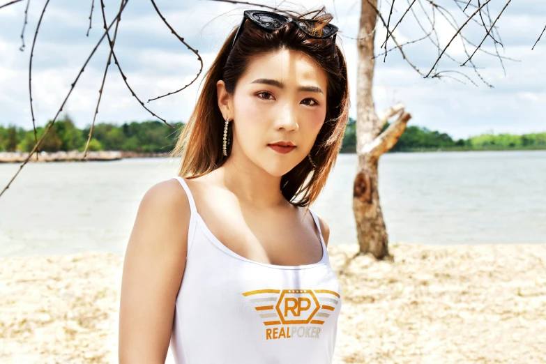 an asian girl in white at the beach wearing a tank top