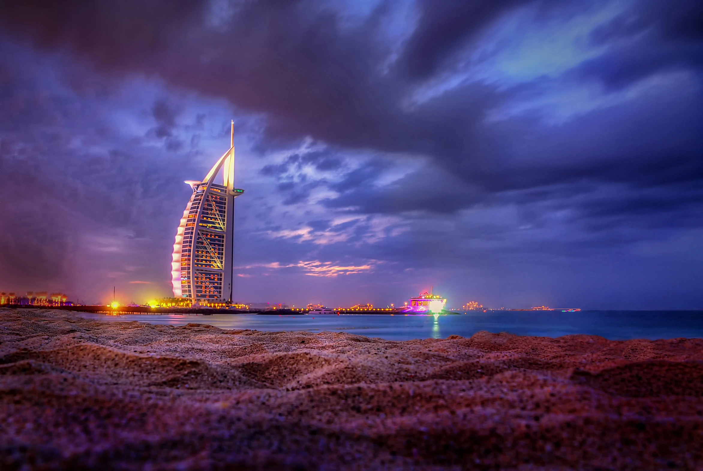 the tower of burjha is pictured in the background at night