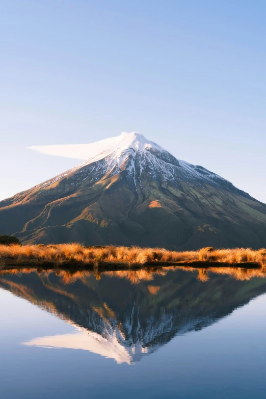 the mountain is shown next to a body of water