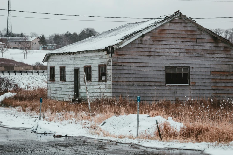 an old building in a field in winter