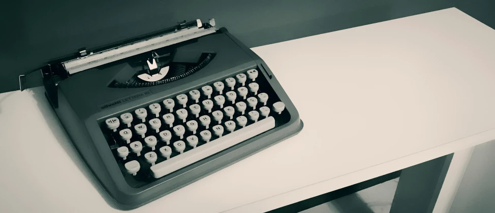 an old typewriter sitting on a white table