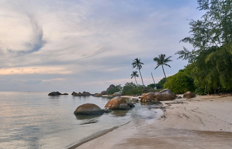 two rocks are shown on the sandy beach