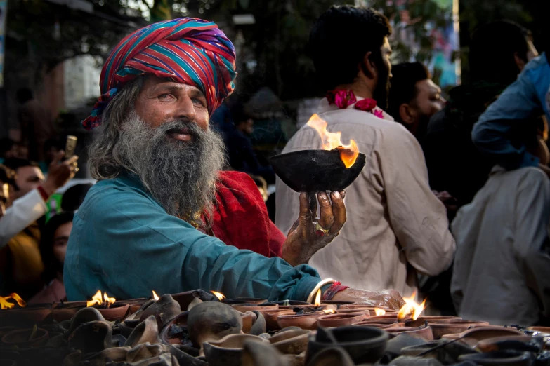 a man with long beard holds a decorative item in his hands