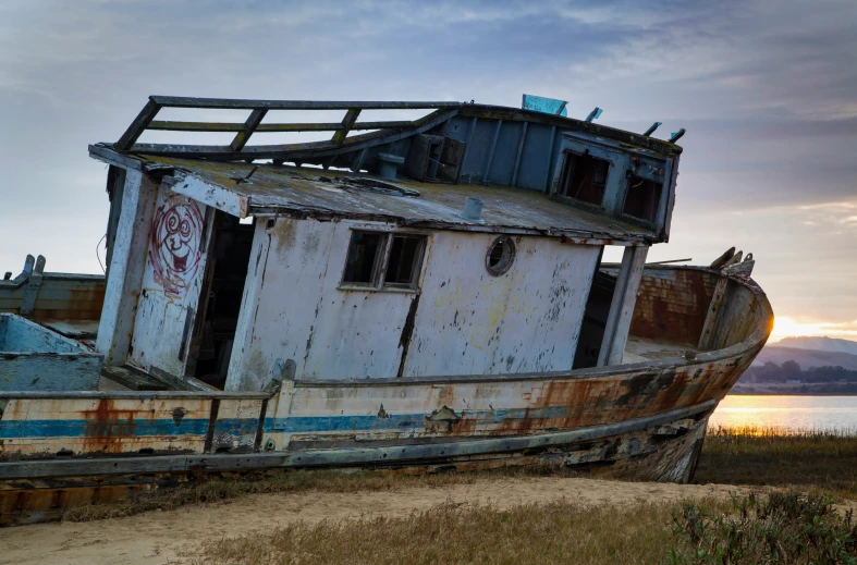 an old boat that is abandoned on a shore