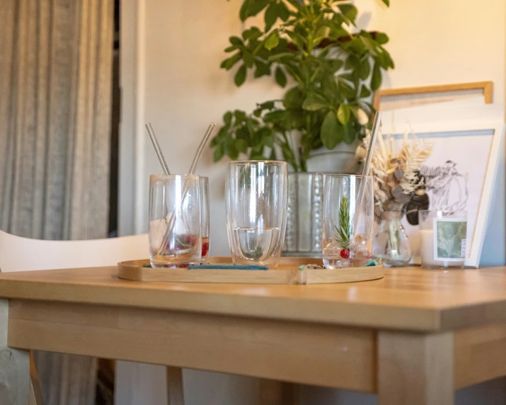 several glasses and plants on a table in a room