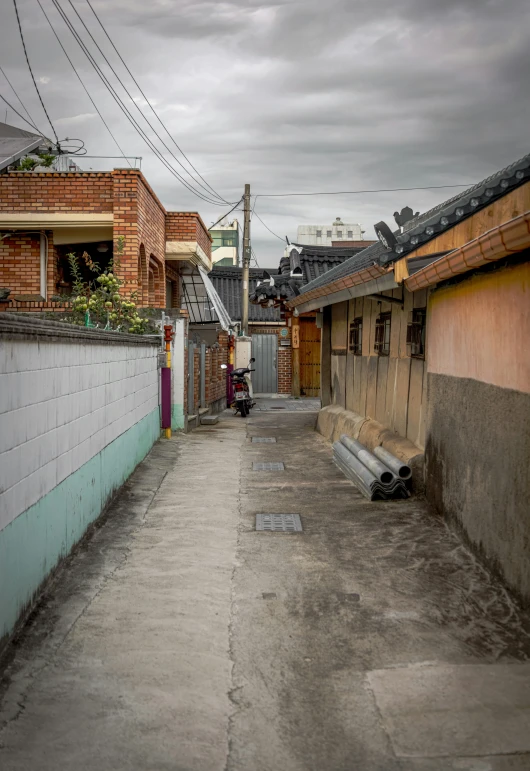 a narrow alley with some buildings and a bench