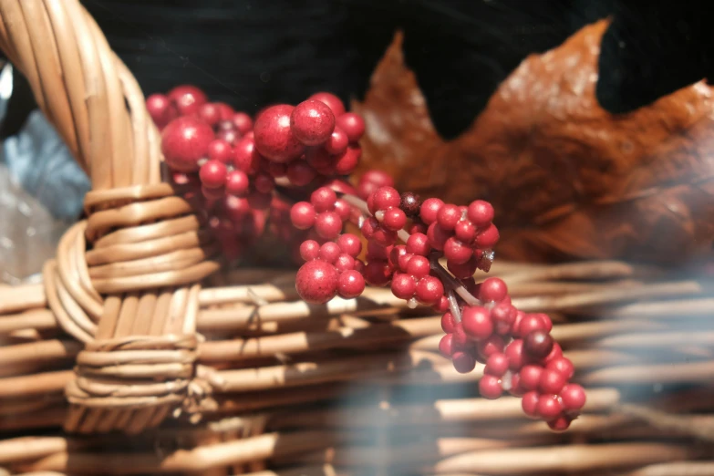 a brown basket with berries and leaves on it