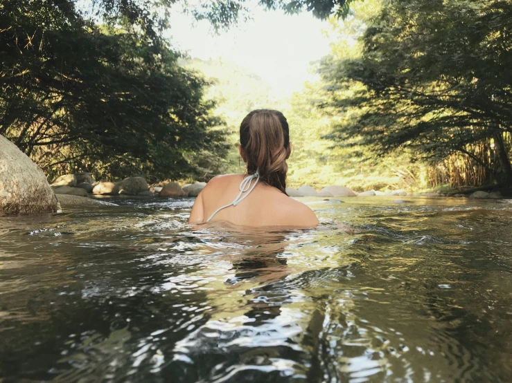 a woman wearing an animal print swimsuit in a creek