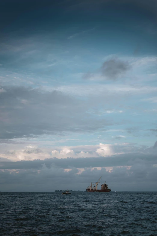 a boat floating across a body of water with another boat in the distance