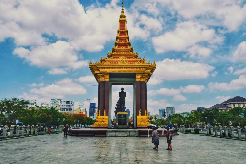 the two people are walking near a statue