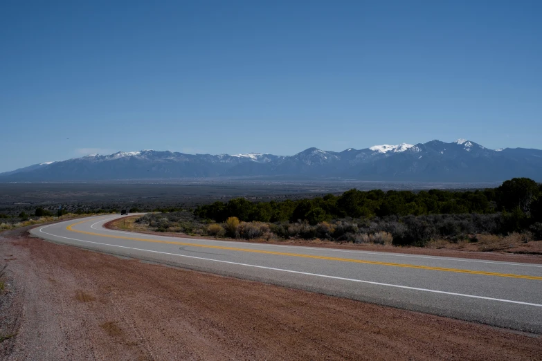 the desert has mountains and scrub trees on one side