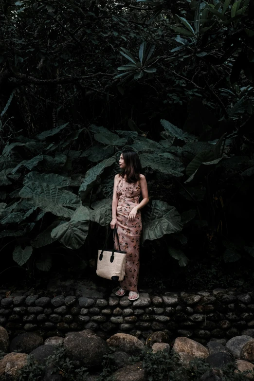 a woman with a brown bag is standing next to plants