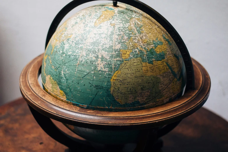 this globe is on a wooden pedestal