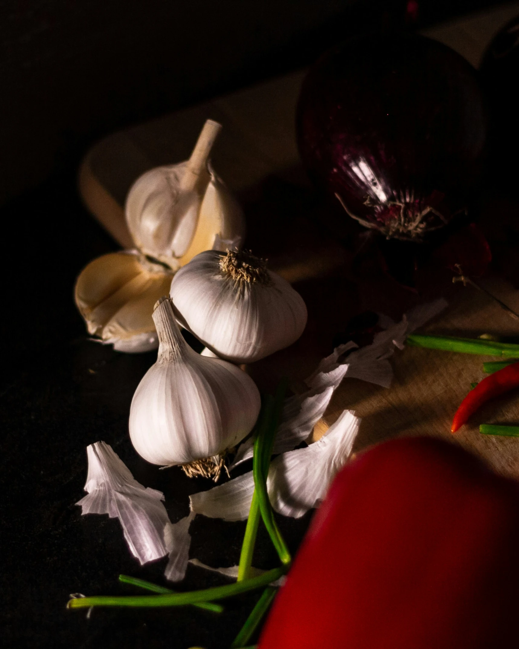 garlic and red peppers are on the table ready to be chopped