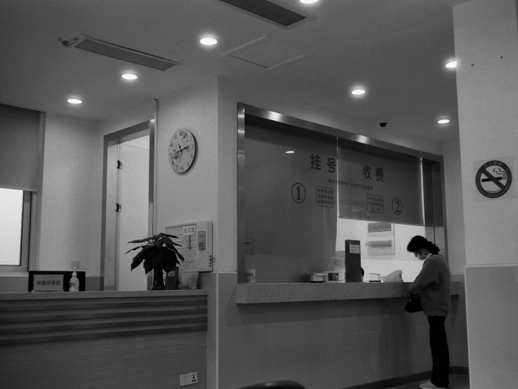 a woman standing at a front desk waiting for her flight