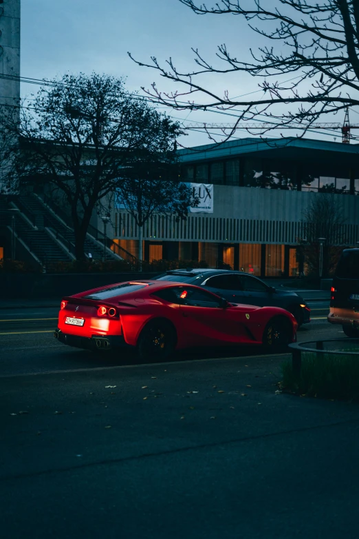 red sports car parked at the curb in an urban setting