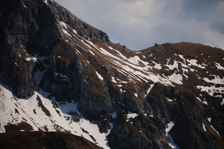 snow covered mountains surround one another in the daylight