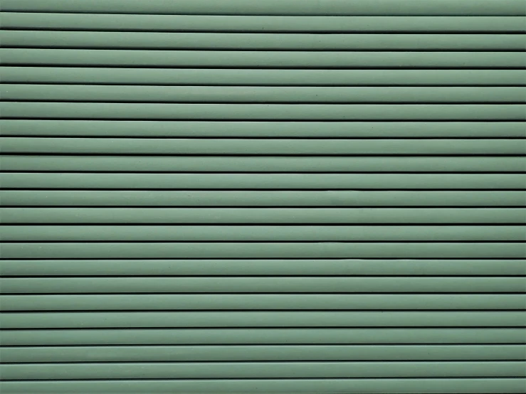 a closed metal door with slats painted green