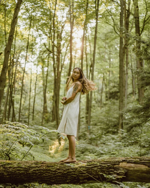  with dreadlocks standing on tree nch in the woods