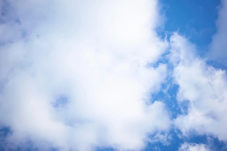 the airplane is flying in the air with white clouds