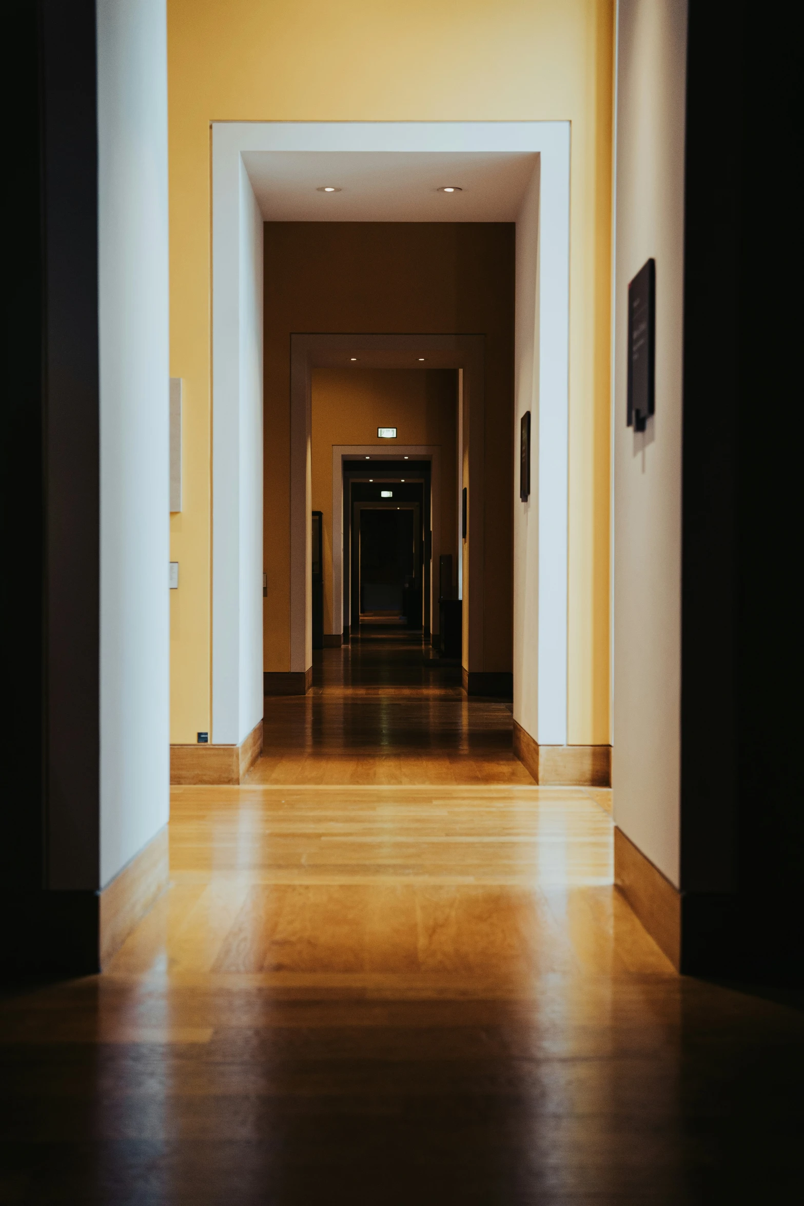 a hallway leading to a room with a large amount of light on the ceiling