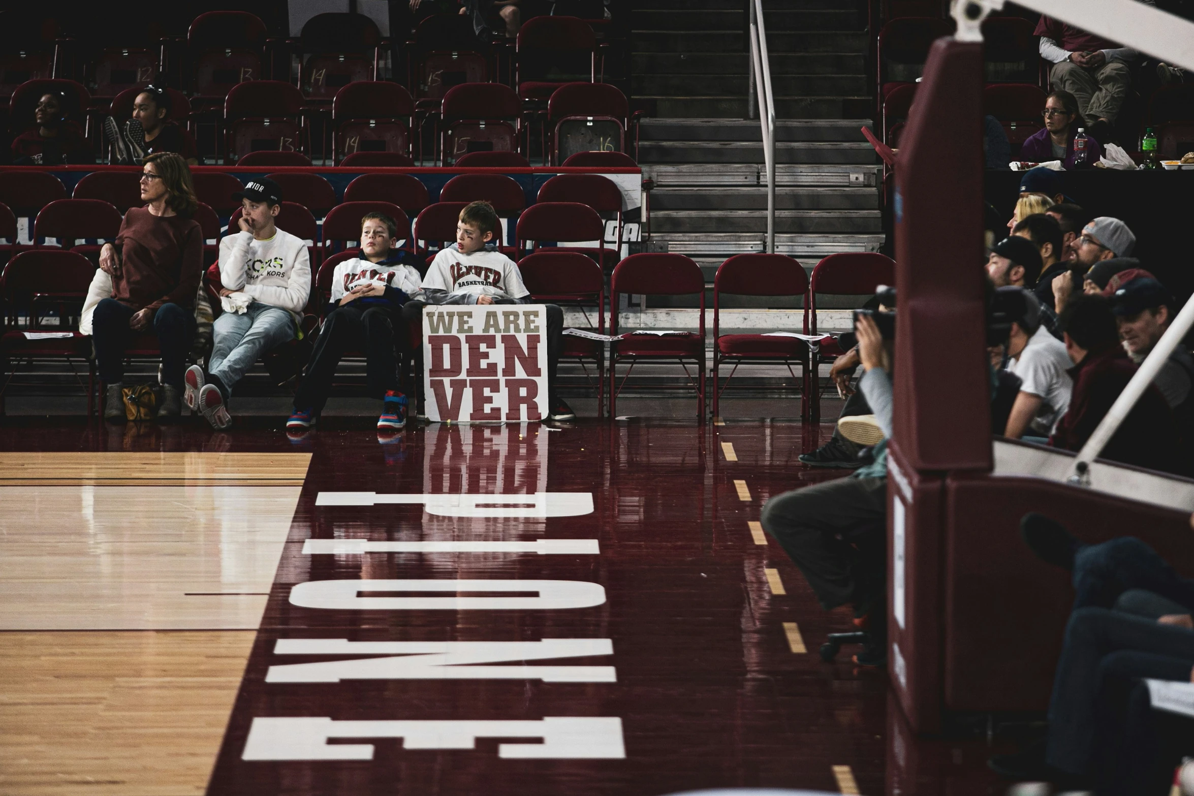 a group of people sitting on top of a gym floor