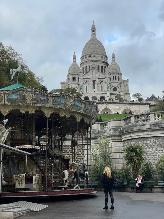 a merry go round in a big city with statues on the ground