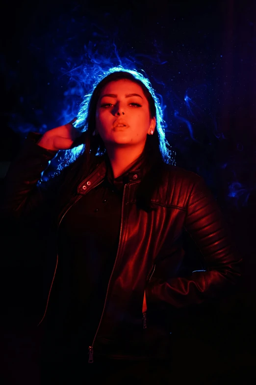 a woman wearing black jacket in front of a neon colored background