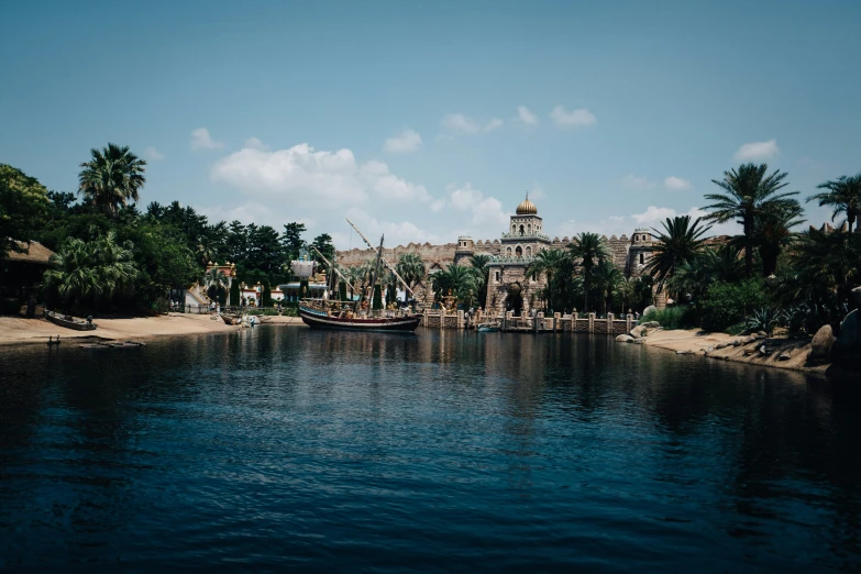 the house is sitting near a boat with palm trees on the side of it