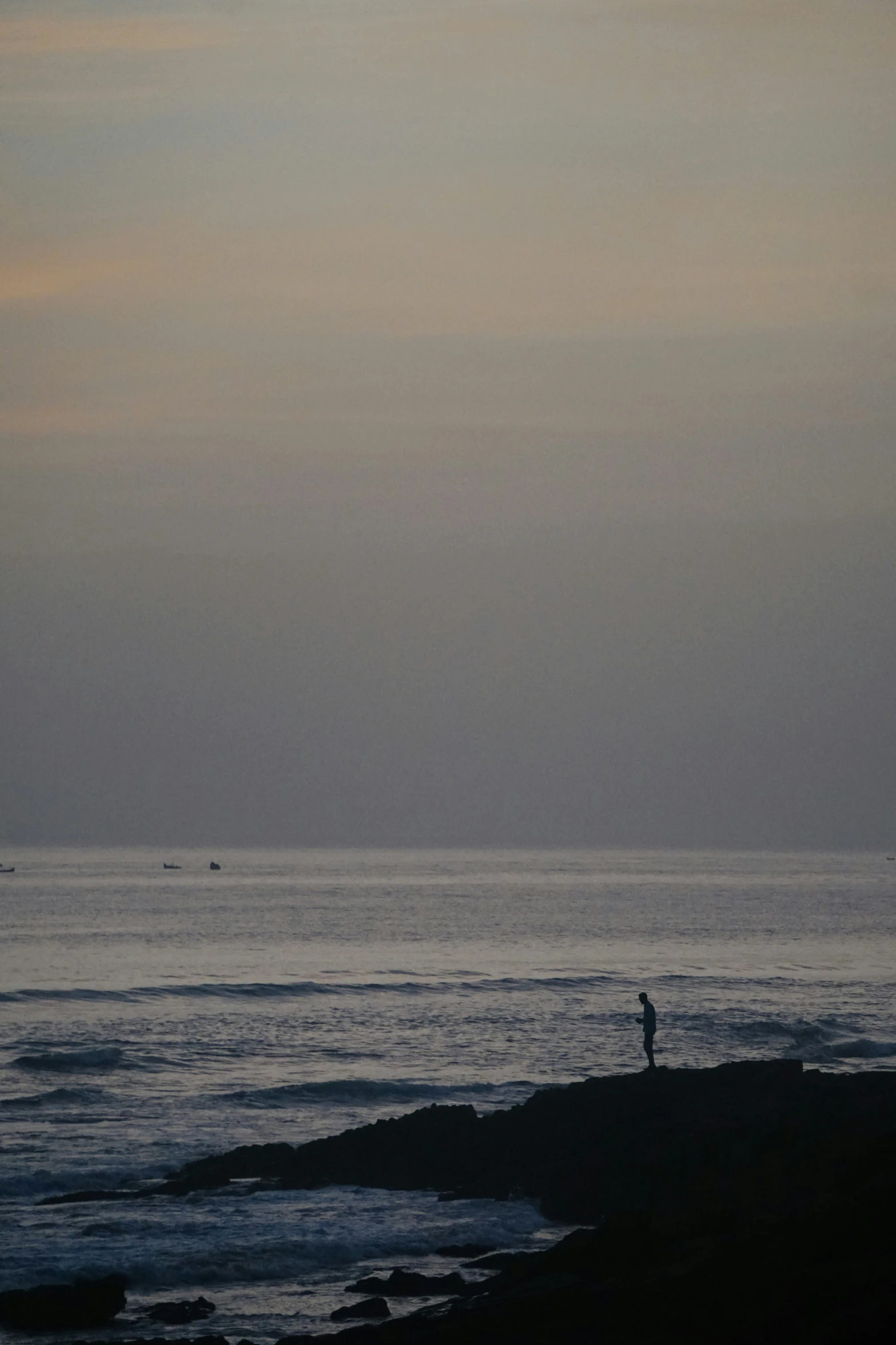 the person is walking out to sea while the birds are flying