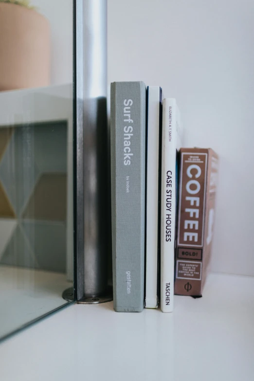 some books that are on a shelf near a mirror