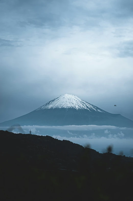 a foggy day with the snow covered peak in the background