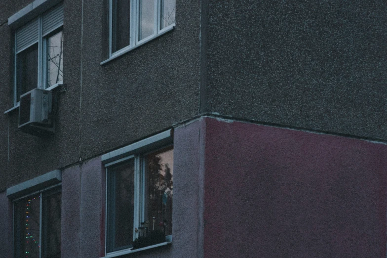 a person in a window standing on the outside of a tall building