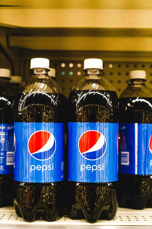 pepsi soda bottles lined up in a fridge