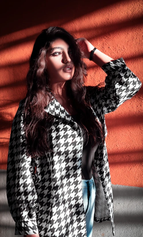 a woman poses in a checkered coat