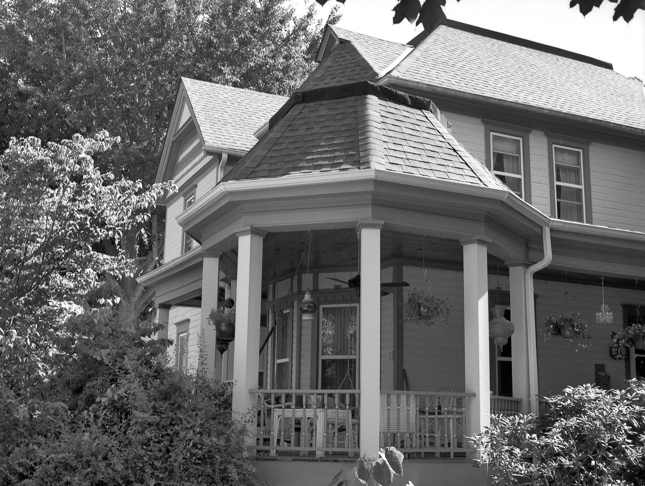 a grey house is surrounded by trees and bushes