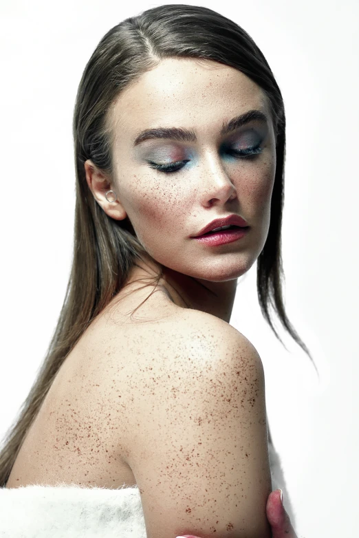 young woman with powdered skin and makeup posing in front of a white background