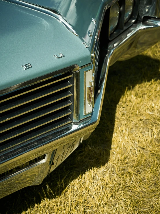 a blue car that is parked on some grass