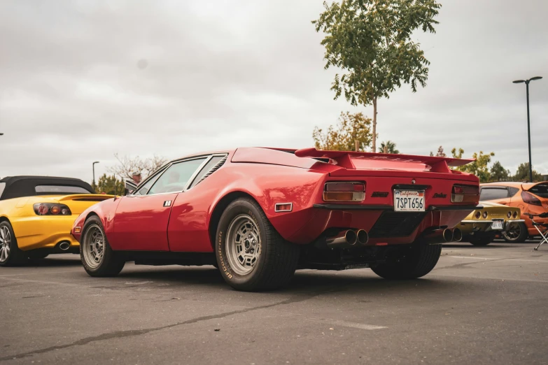 a red car is parked in front of other cars