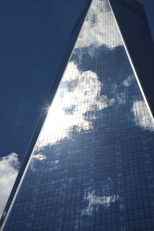 a very tall glass skyscr with windows reflecting the sky