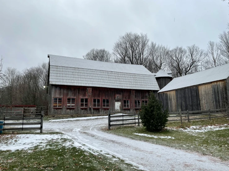 the barn and field is snow - covered