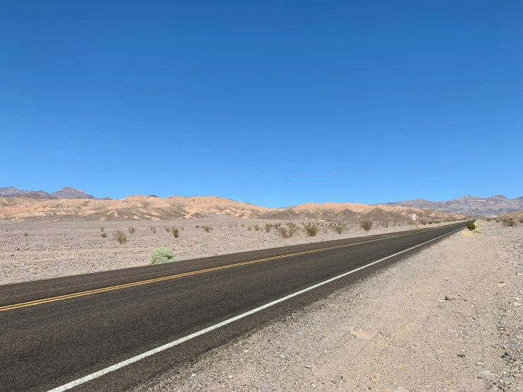 a long highway in the desert during a sunny day