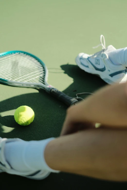 a person holding a tennis racket on a court with a ball