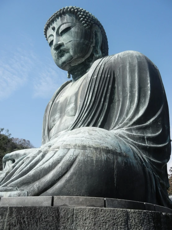 the large buddha statue is sitting by itself